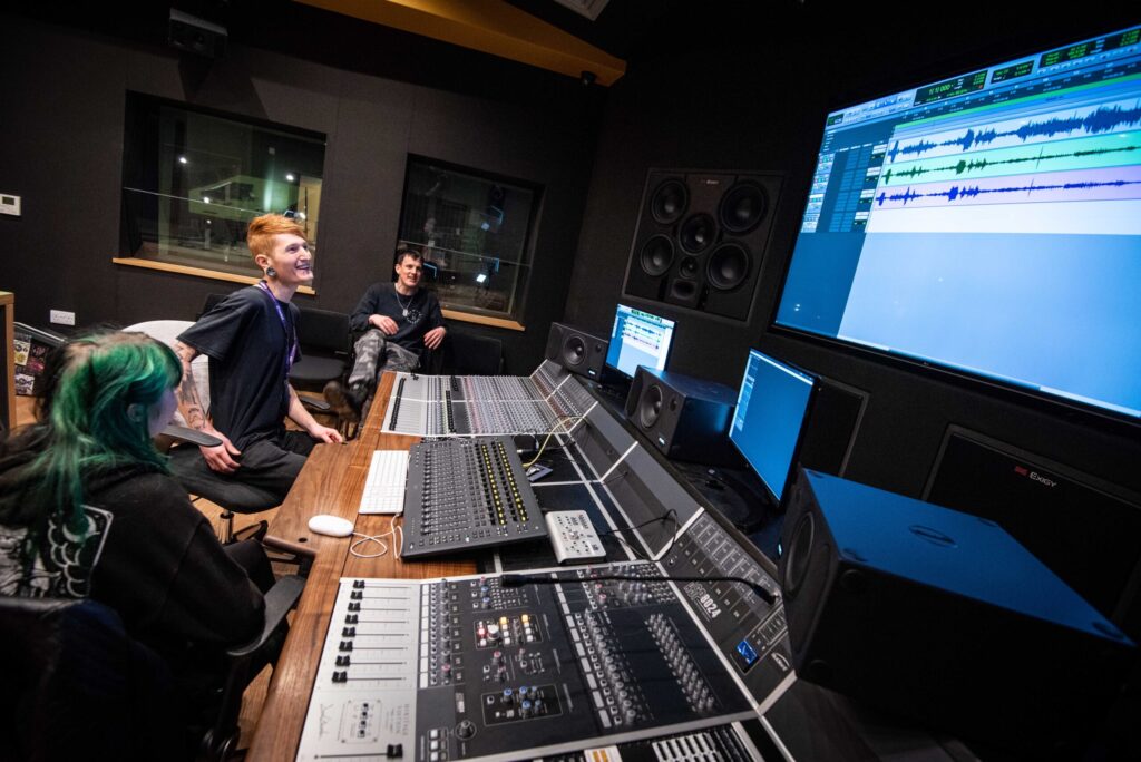 Students using a mixing desk in a studio