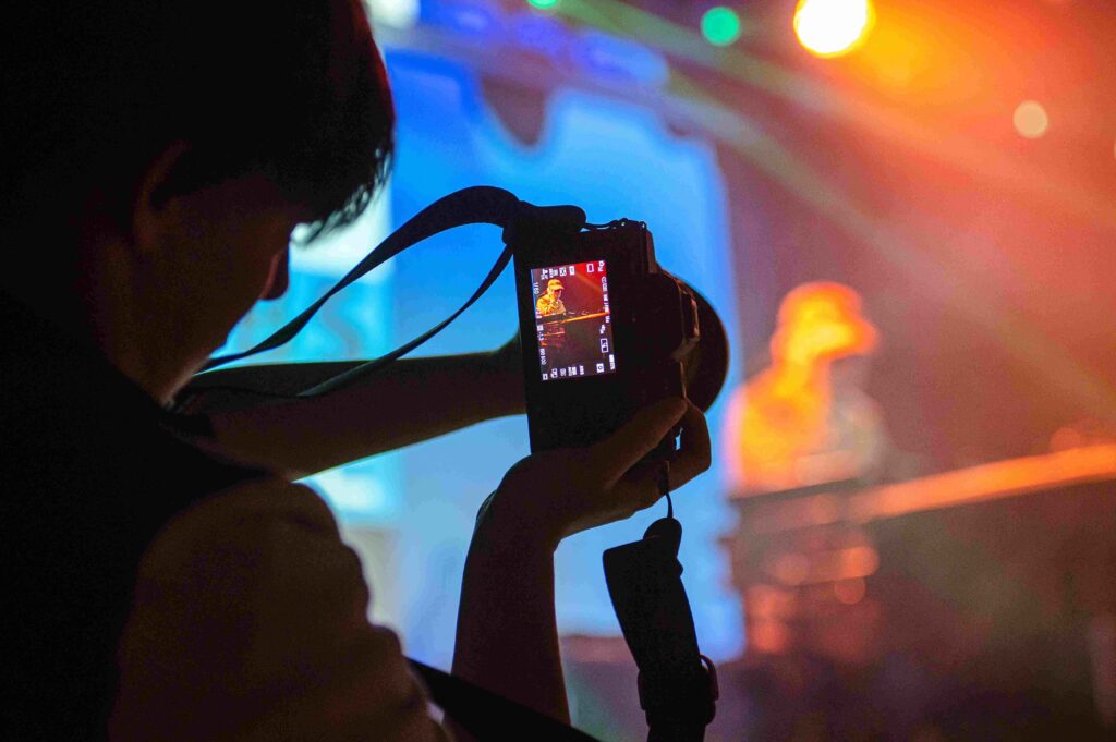 Someone taking a photograph of an artist on stage