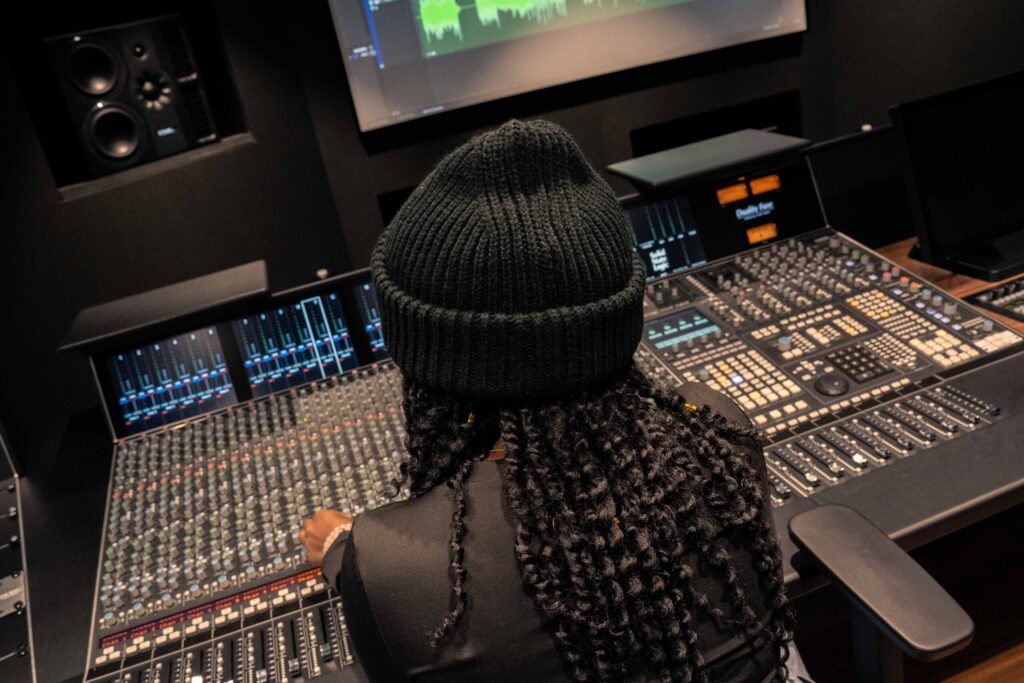 Student using a mixing desk in a music studio