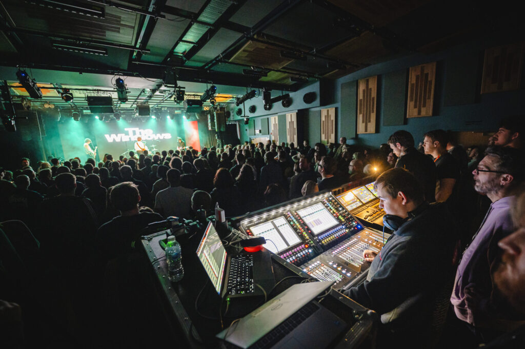 Students operating the lighting and sound decks at a concert