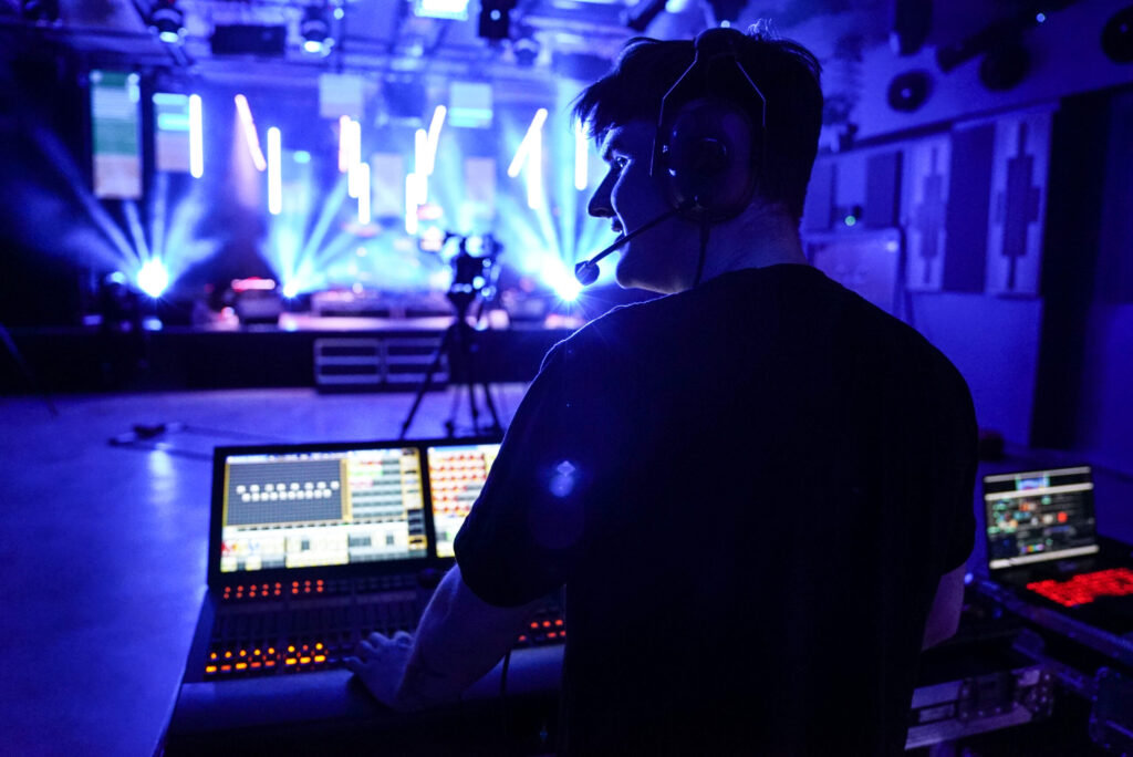 Student operating the lighting and sound decks at a concert