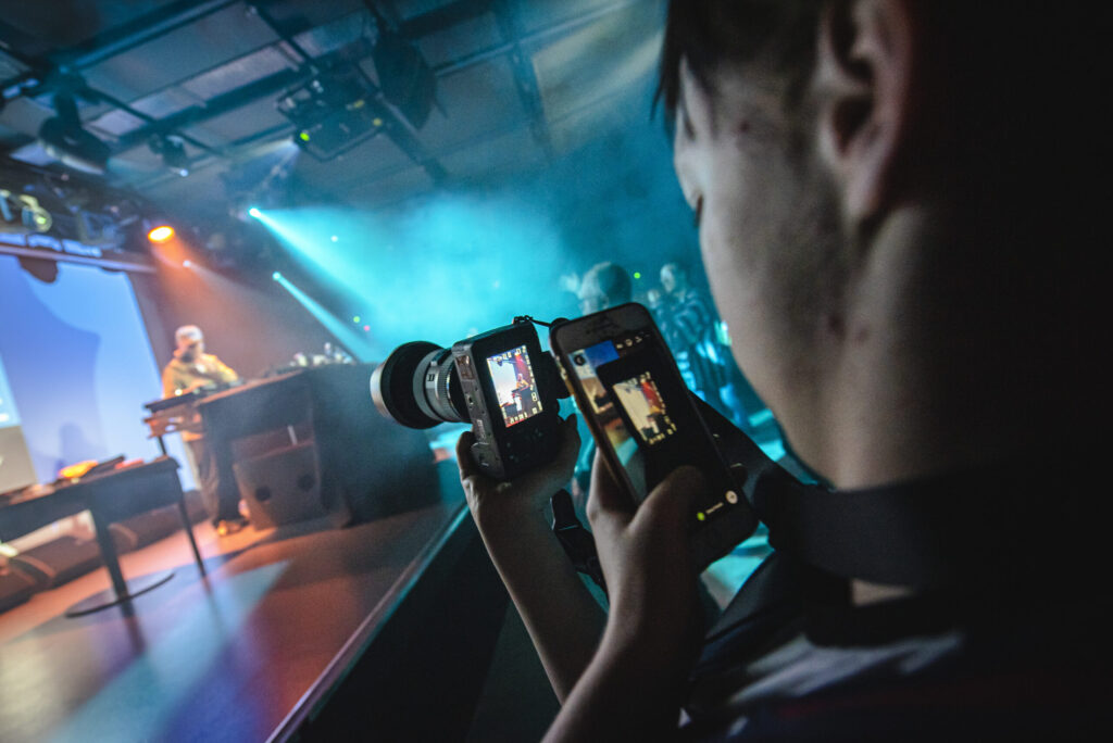Student taking photographs at a concert