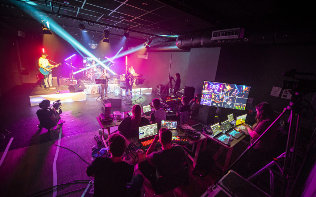 Students performing, controlling the lighting and sound, and managing a live set