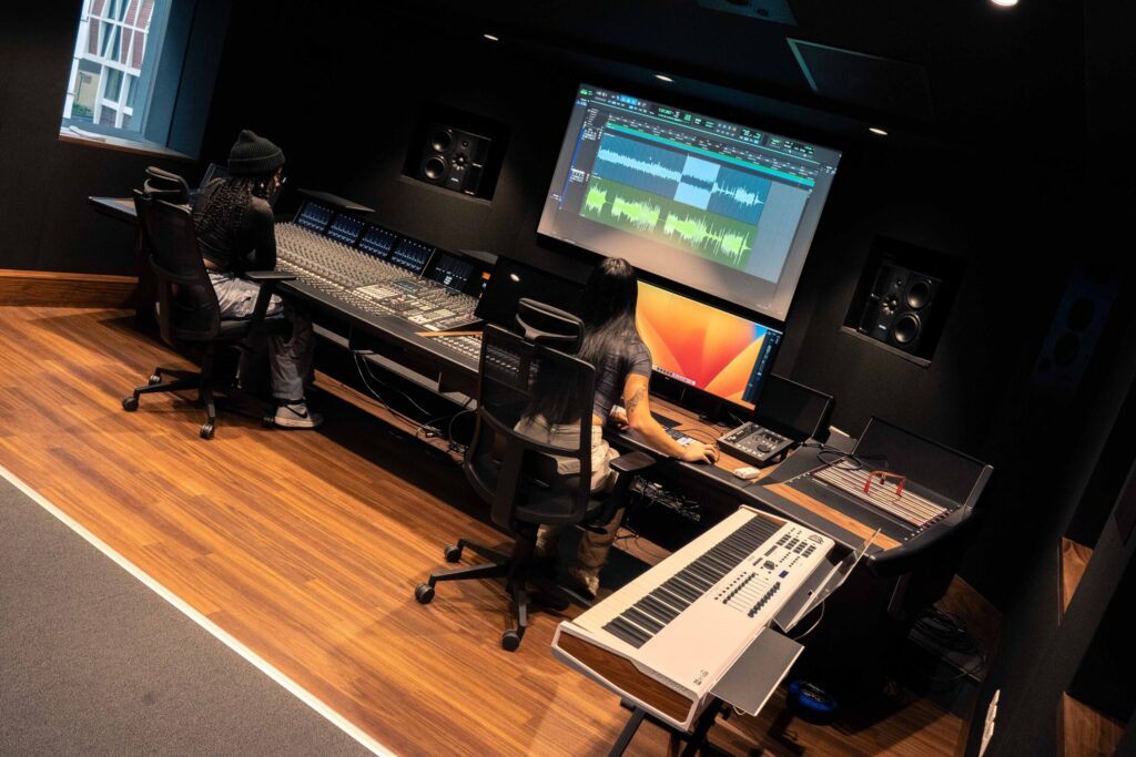 Students using a mixing desk in a music studio