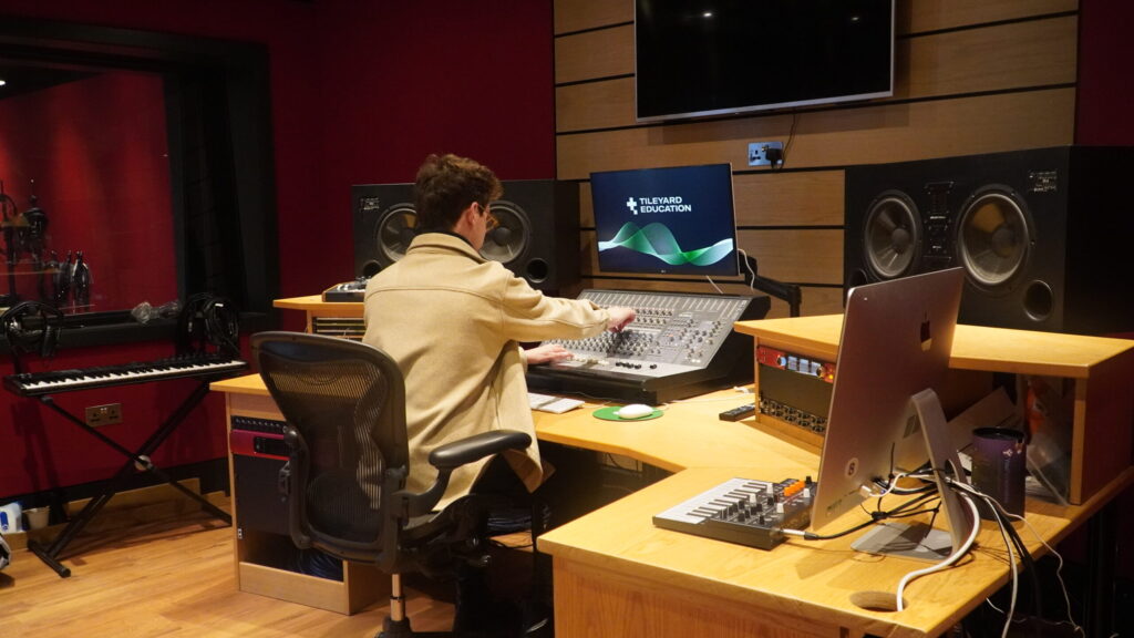 Student producing music in a studio