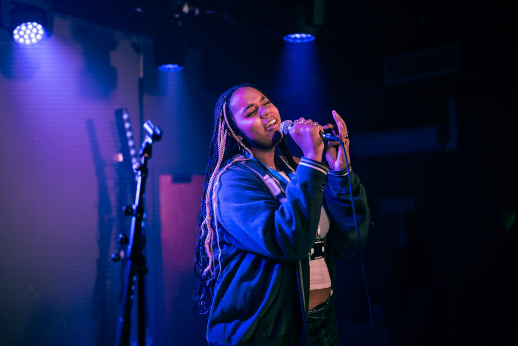 Student singing into a microphone on stage