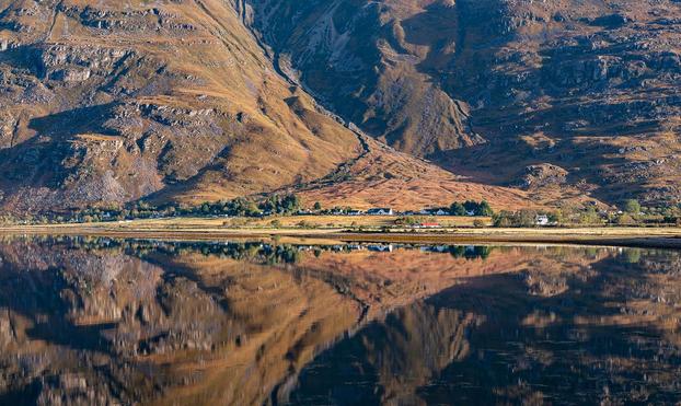 Mountain reflected in a still sea.