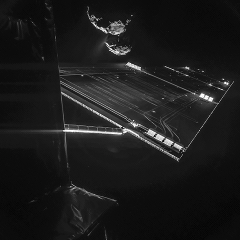 Image of a Rosetta spacecraft solar array in foreground and the nucleus of comet 67P in background.