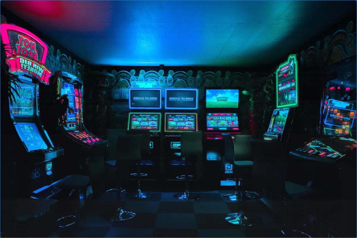 Dimly lit arcade with slot machines and neon lights