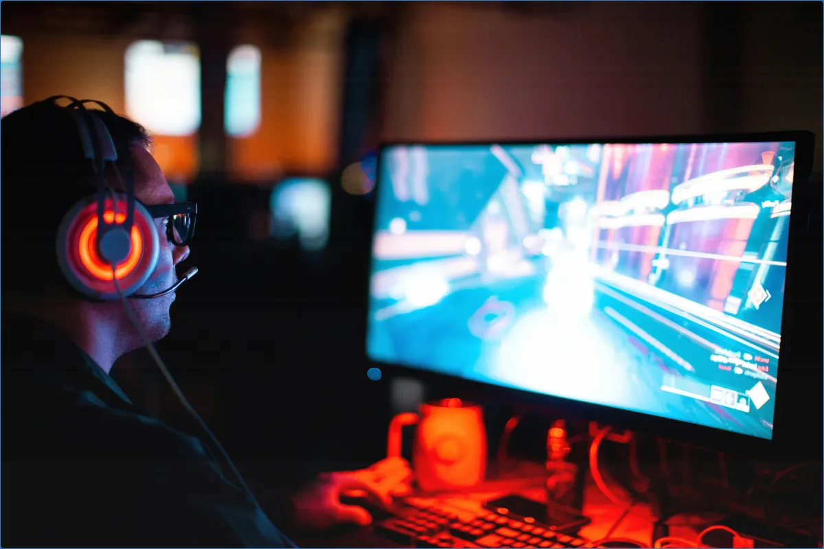 Person gaming on a computer with headphones