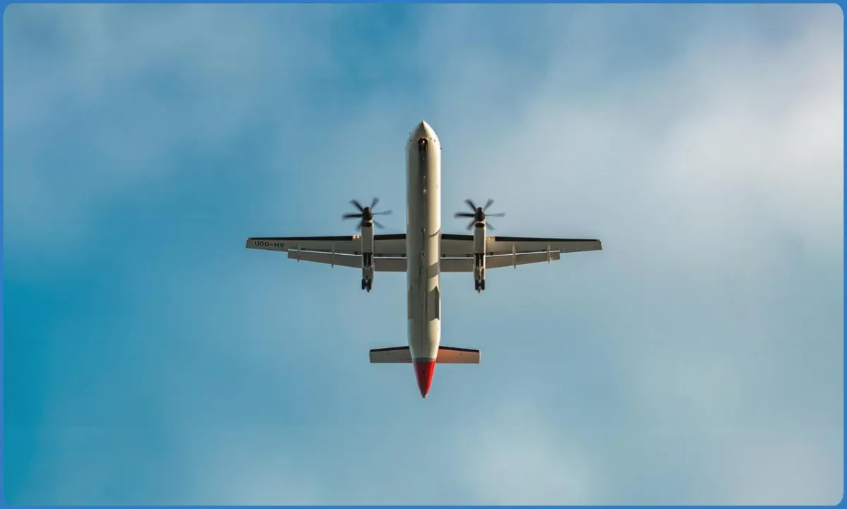 Airplane flying overhead against blue sky