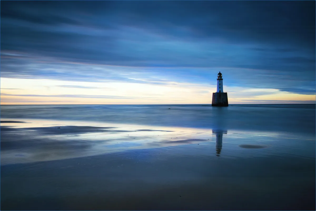 Lighthouse on calm sea at dusk