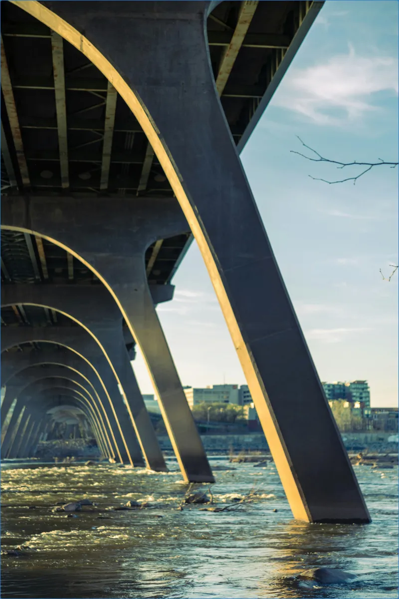 Underneath view of a bridge over a river.