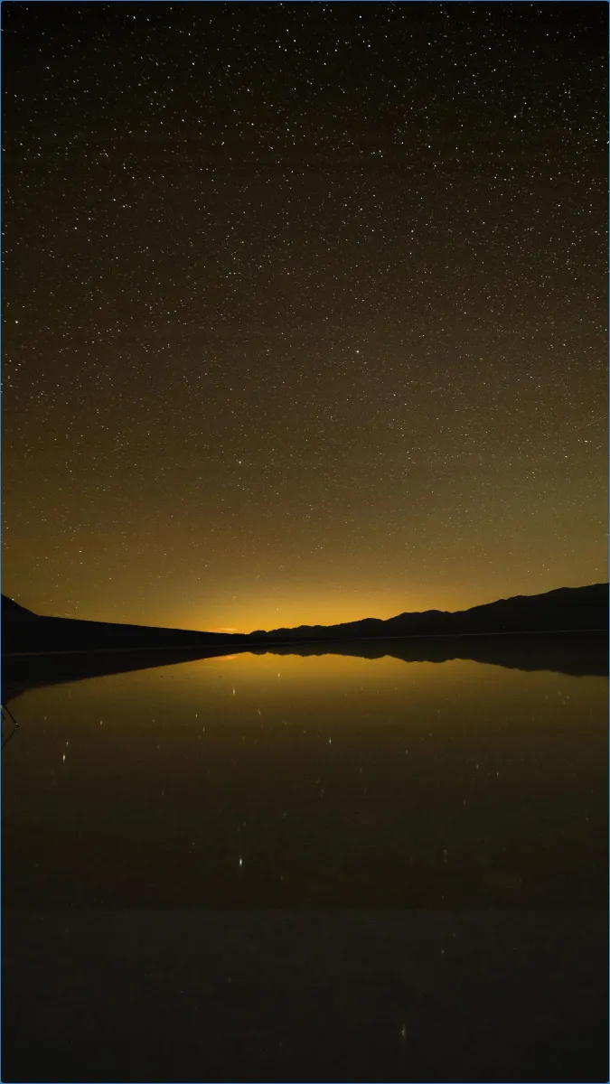 Starry night sky over a calm lake
