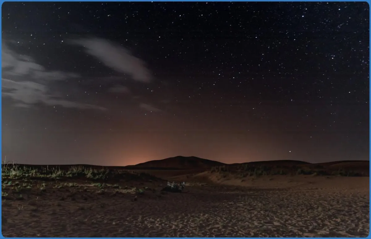 Starry night sky over a desert landscape