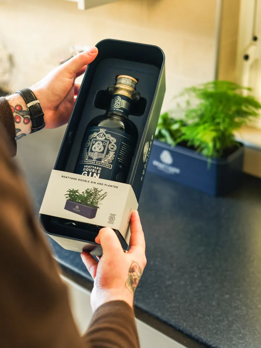 Person holding a boxed bottle of gin