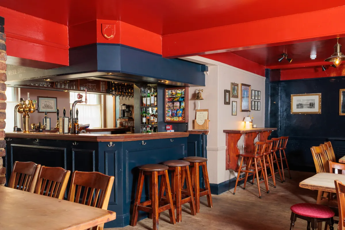 Interior of a cozy pub with a bar and seating.