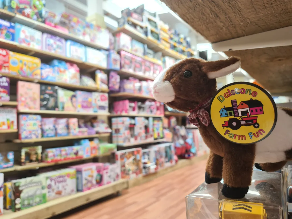 Stuffed animal with Dalcone Farm Fun tag in toy store.