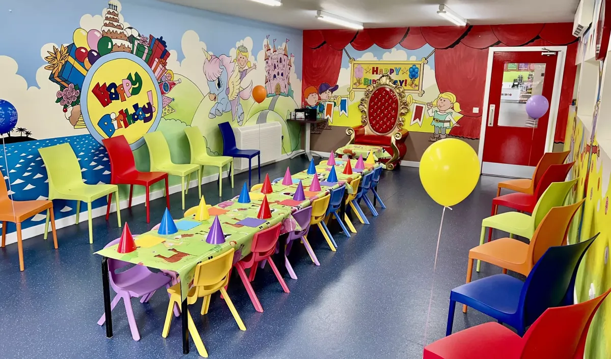 Colorful children's party room with decorated tables.