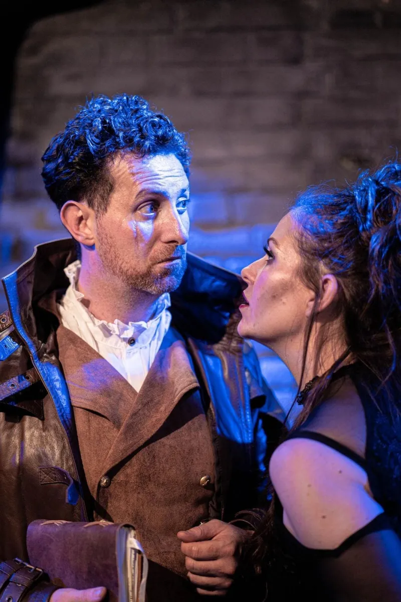 Two actors in dramatic scene with intense expressions.