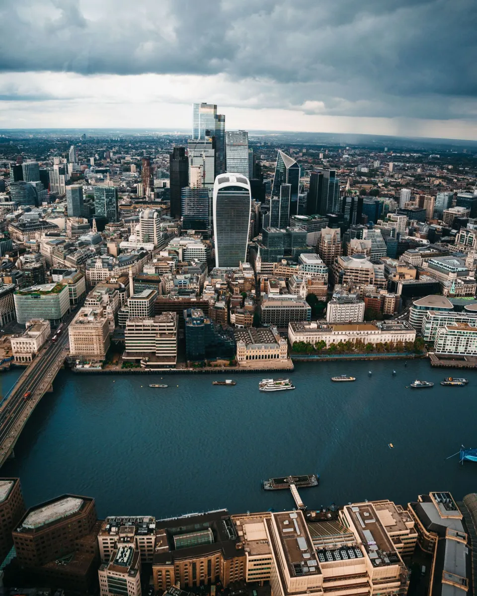 Aerial view of London cityscape with skyscrapers and river.