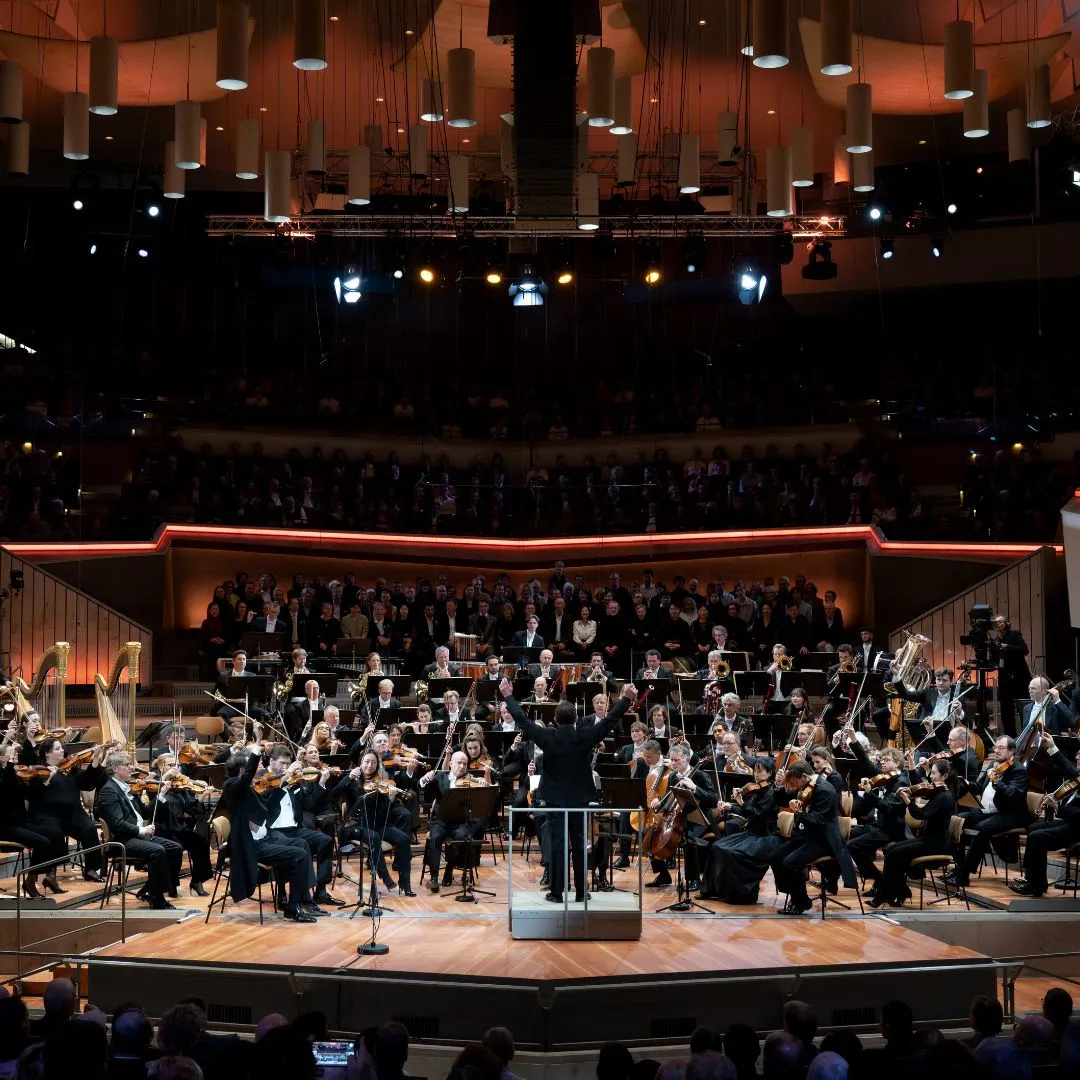 Orchestra performing on stage with conductor