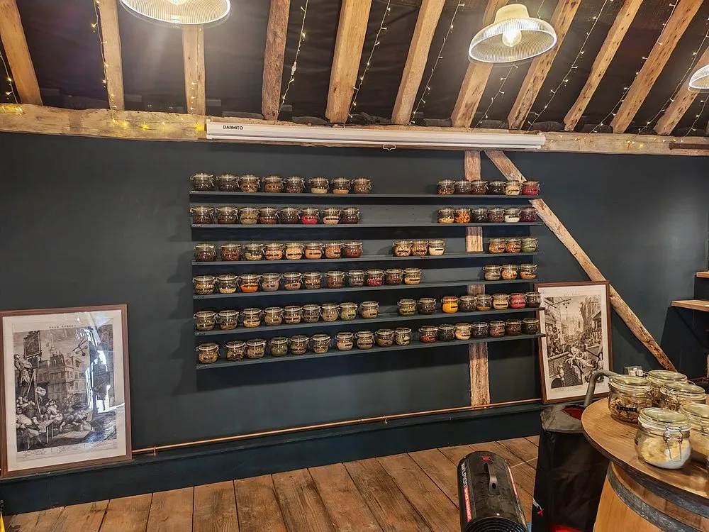 Wall with shelves of spice jars in a rustic room.