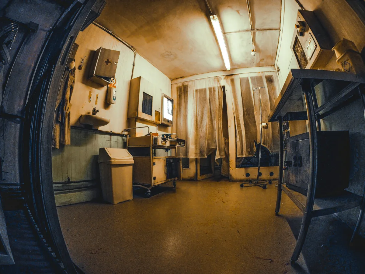 Dimly lit, vintage medical room with equipment.