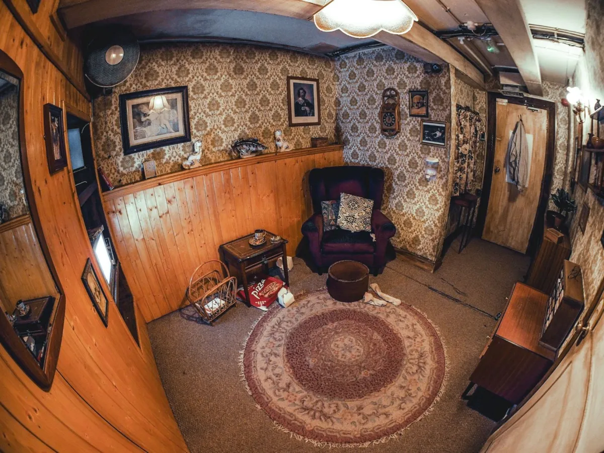 Vintage living room with patterned wallpaper and armchair.