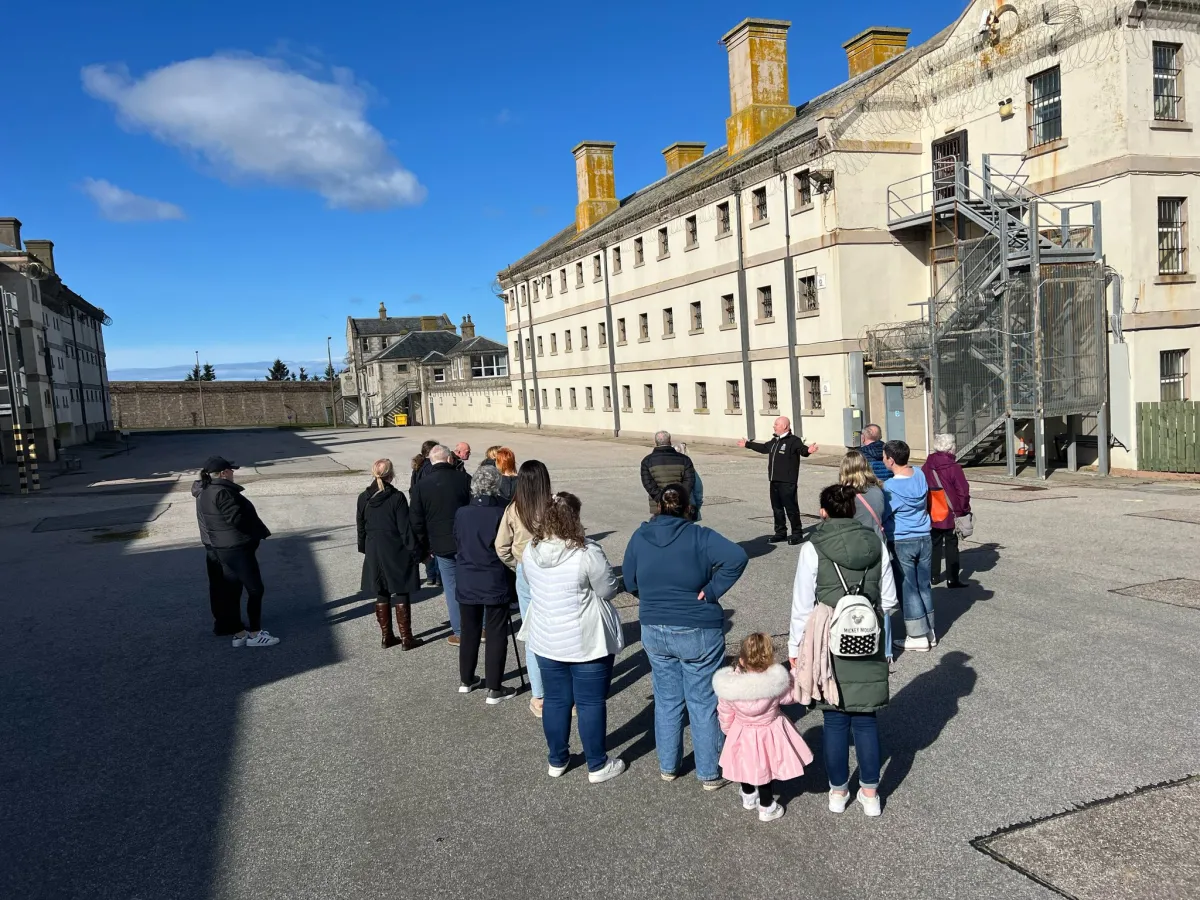 Group of people on a guided tour outside a historic building.