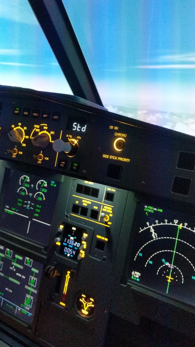 Airplane cockpit controls and display screens.