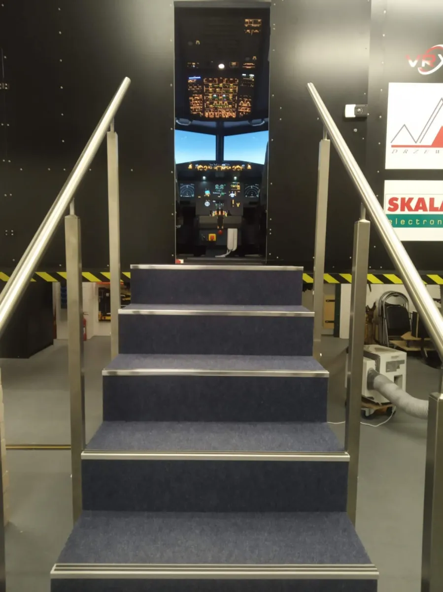 Stairs leading to a flight simulator cockpit.