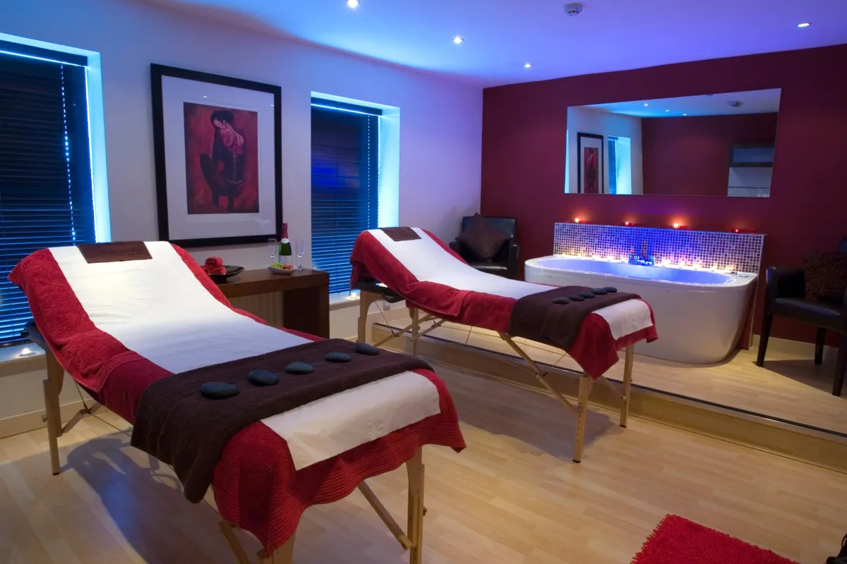 Spa room with massage tables and a bathtub.