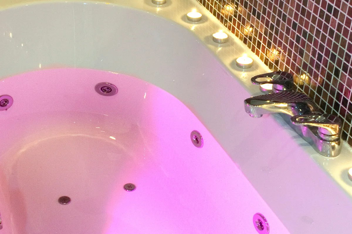 Bathtub with candles and pink lighting