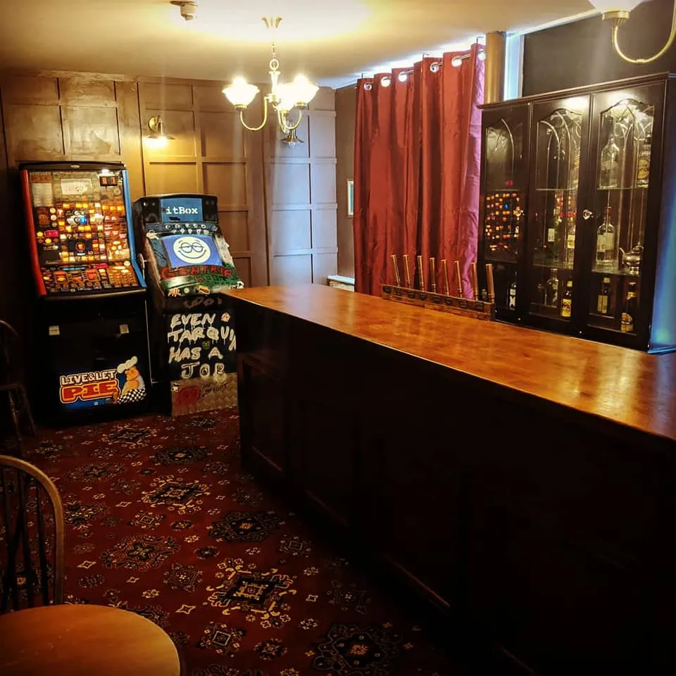 Empty pub bar with gaming machines and a cabinet.