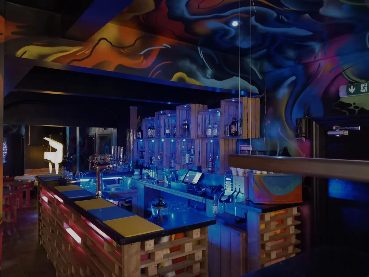 Colorful bar interior with wooden pallets and graffiti walls