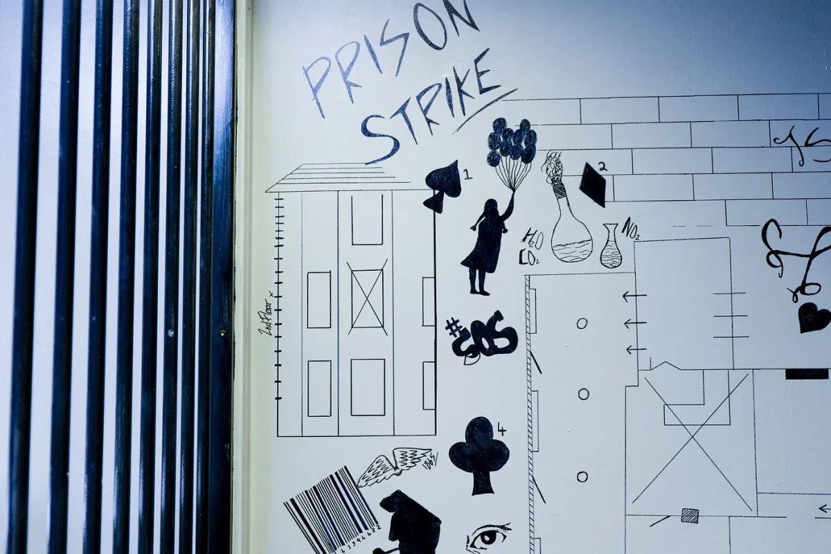 Wall art with text 'Prison Strike' and various drawings.