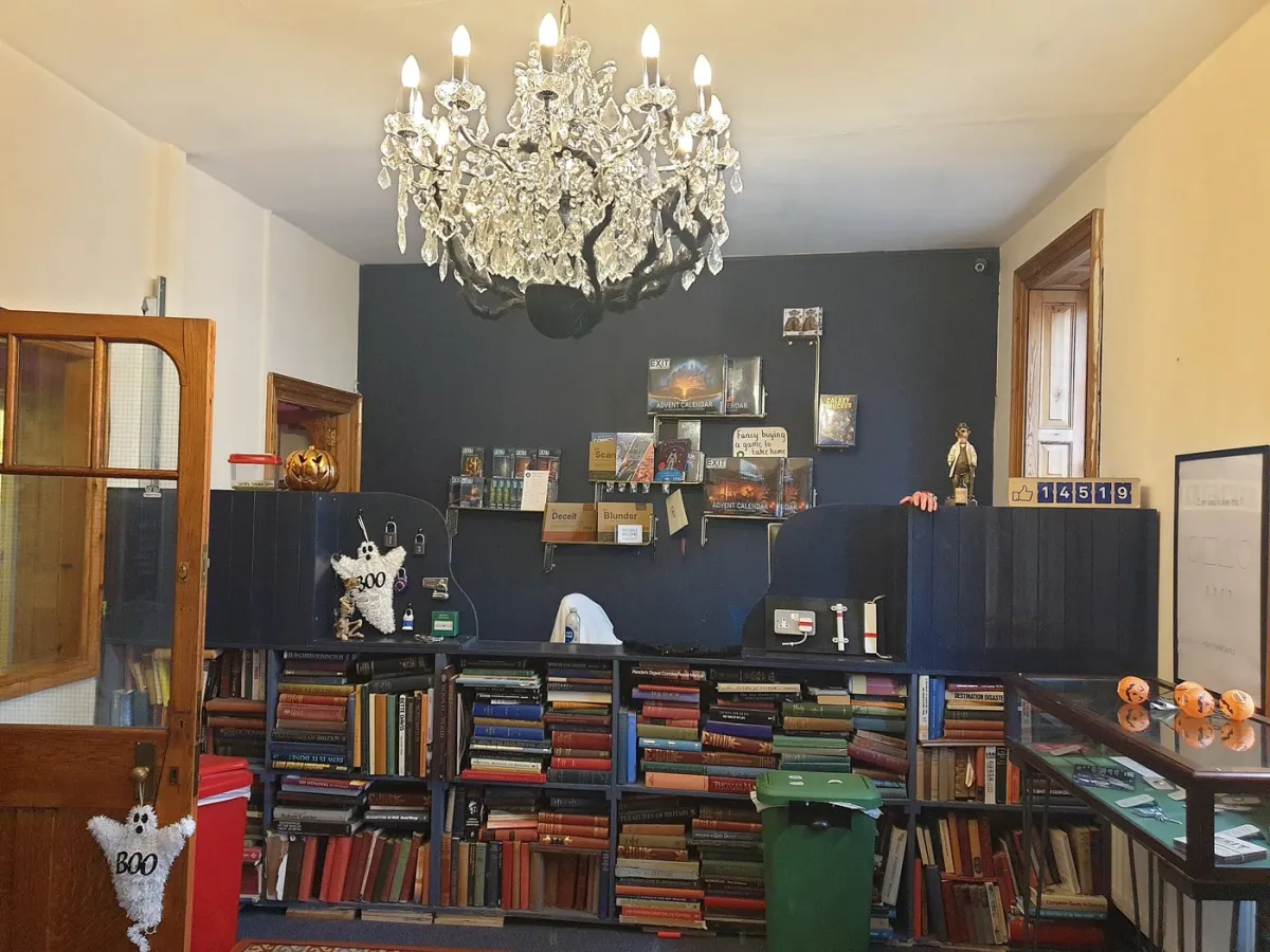 Room with bookshelves, chandelier, and Halloween decorations.