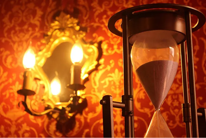 Hourglass and ornate mirror with candles