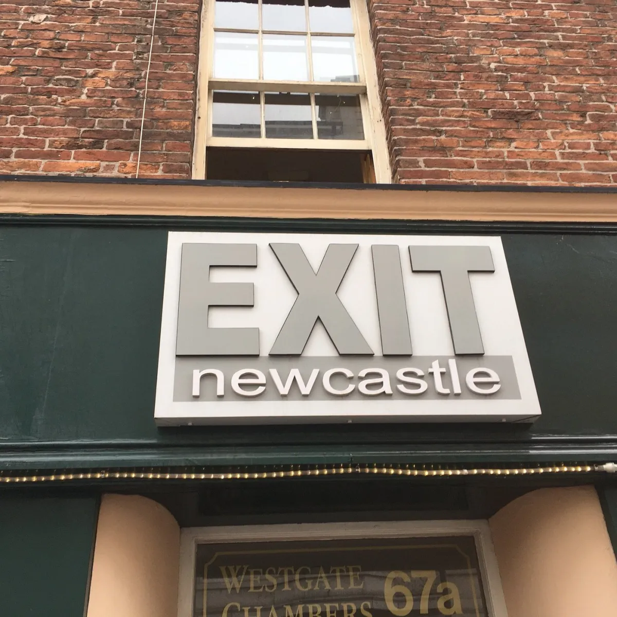 Sign reading 'EXIT newcastle' on a building