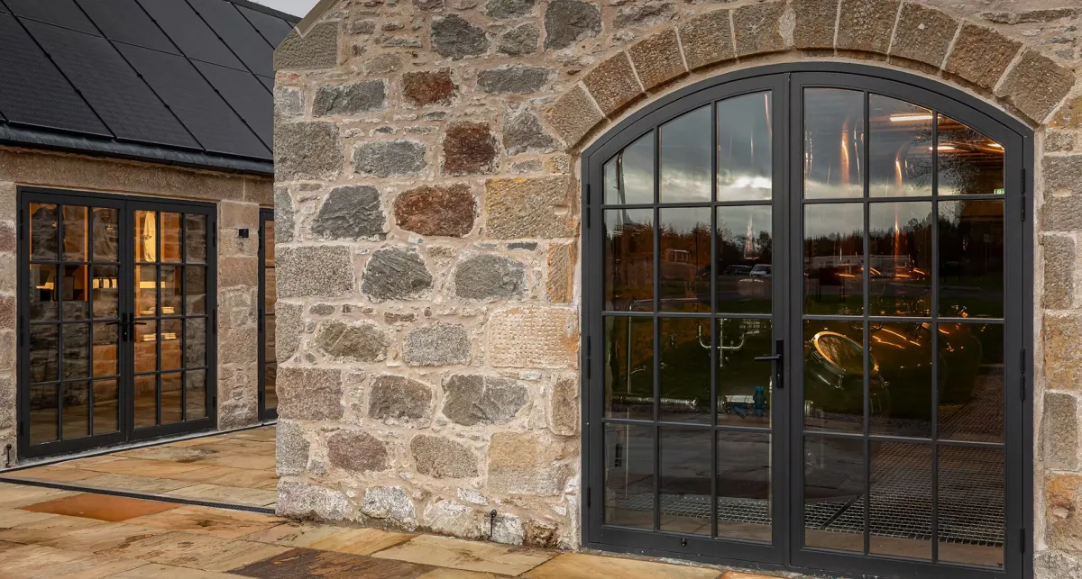 Stone building with large glass doors.
