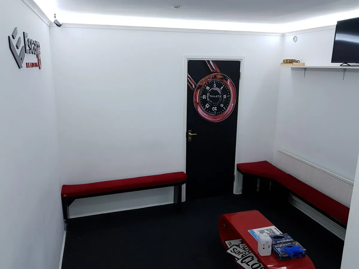 Small waiting room with benches and a clock-themed door.