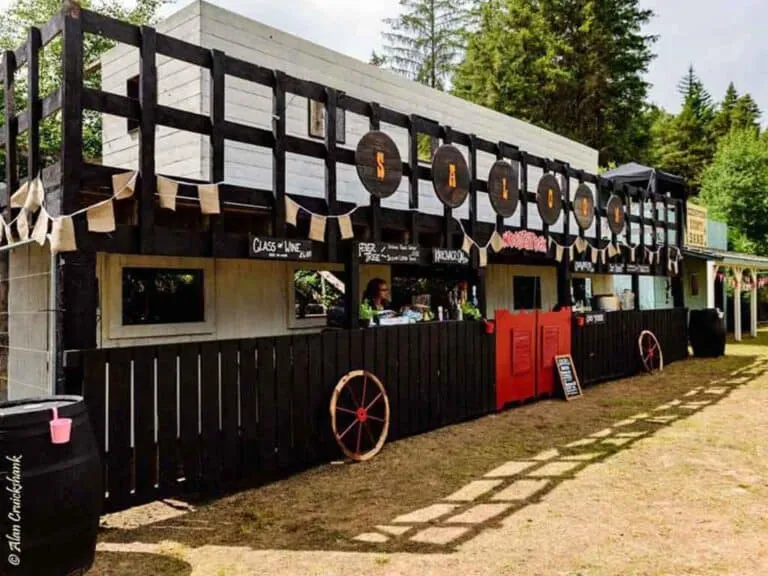 Wooden saloon with decorative barrels and wagon wheels.