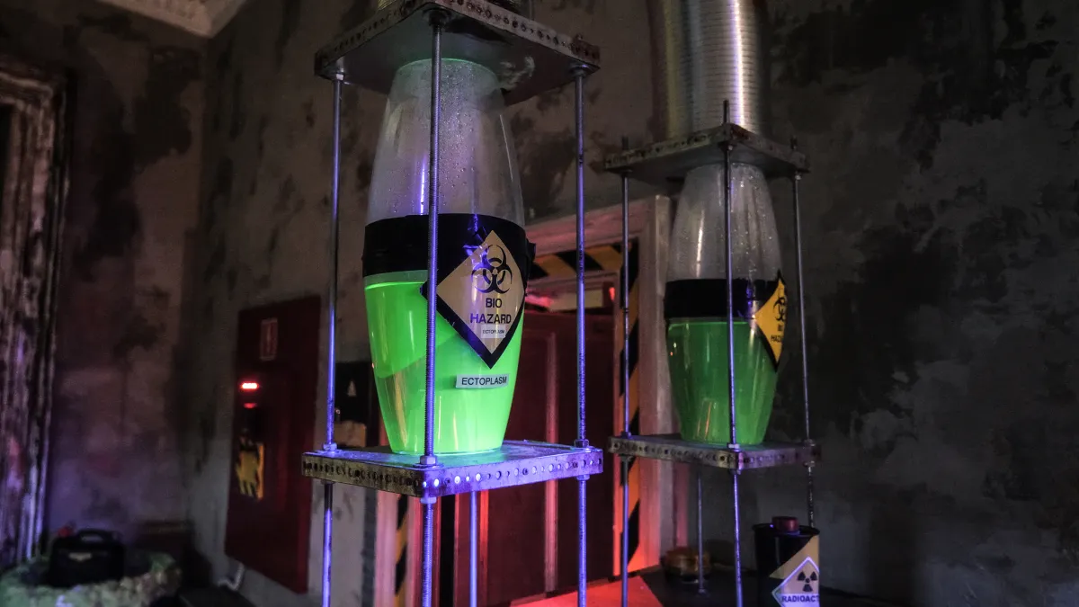 Containers with glowing green liquid labeled biohazard.