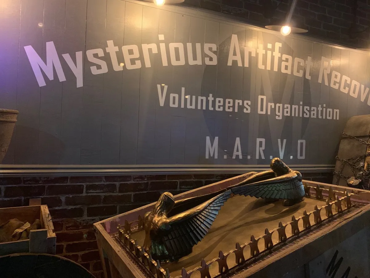 Sign reading 'Mysterious Artifact Recovery Volunteers Organisation' with an artifact.