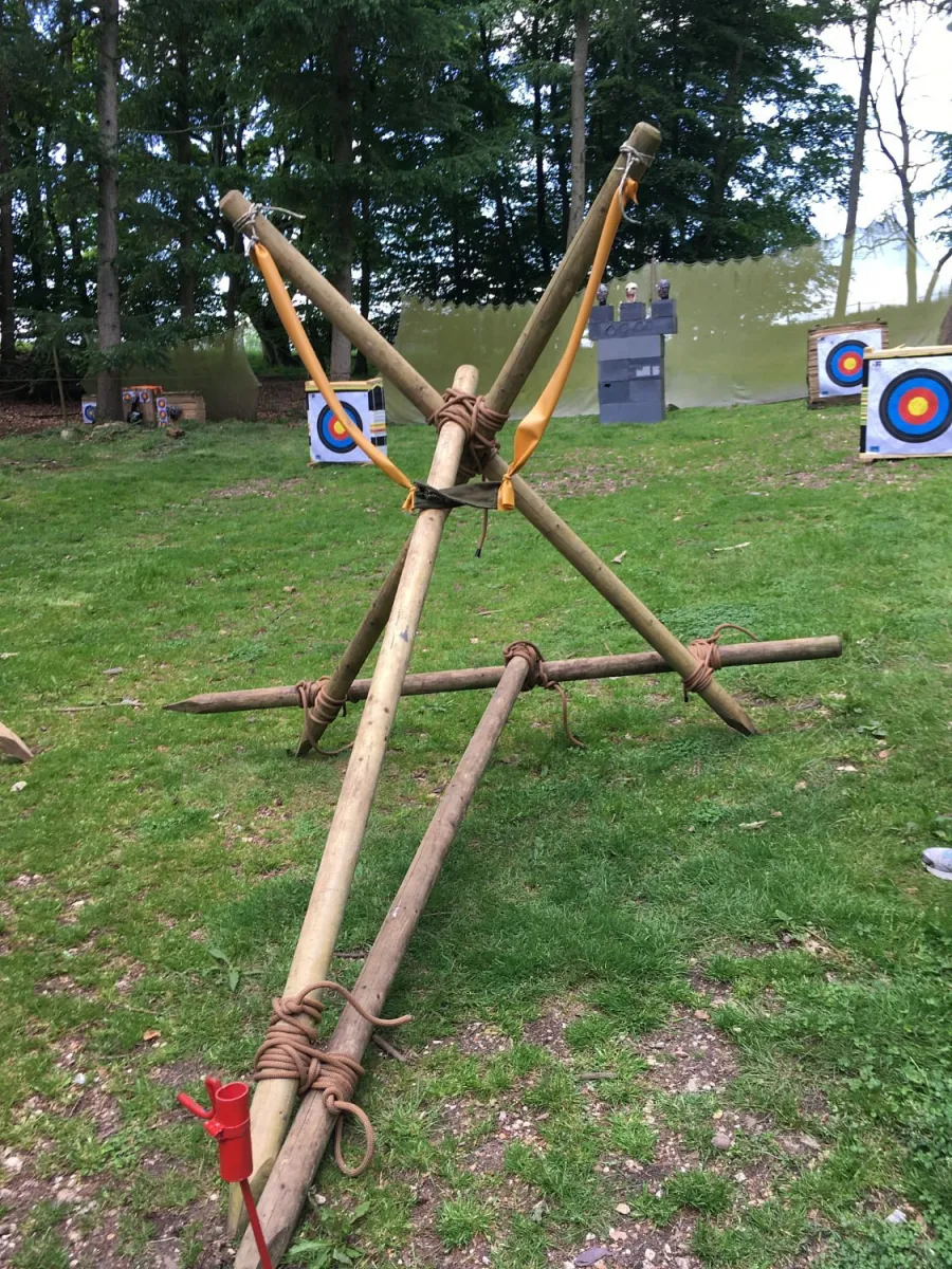 Large wooden slingshot in a field with targets