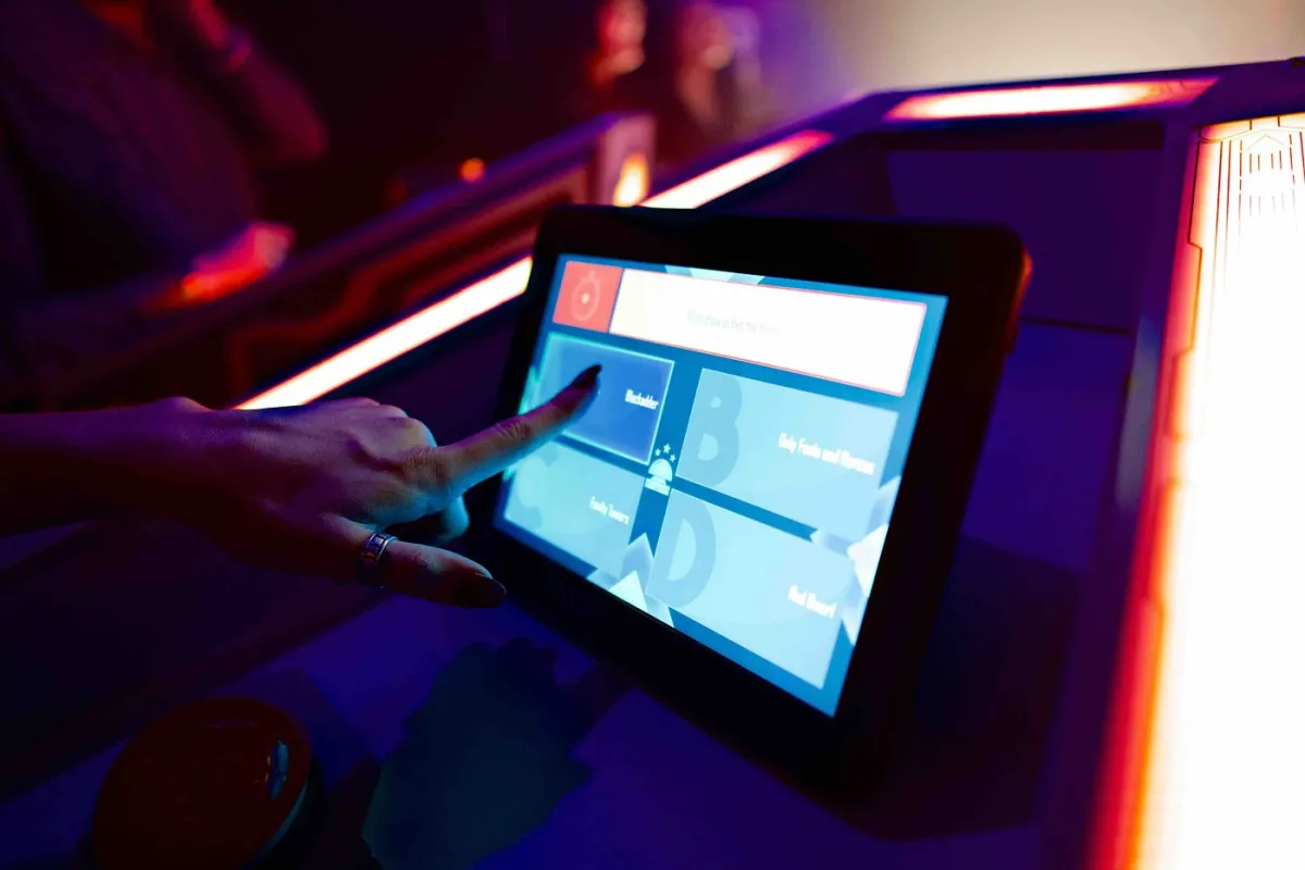 Person interacting with a touchscreen in low light.