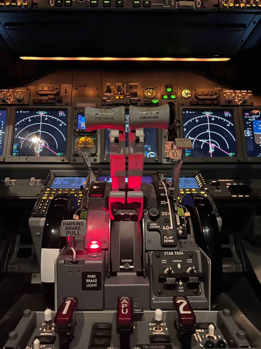 Cockpit controls of an aircraft with illuminated panels.