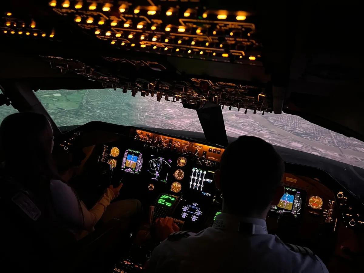 Two people in an airplane cockpit simulator.