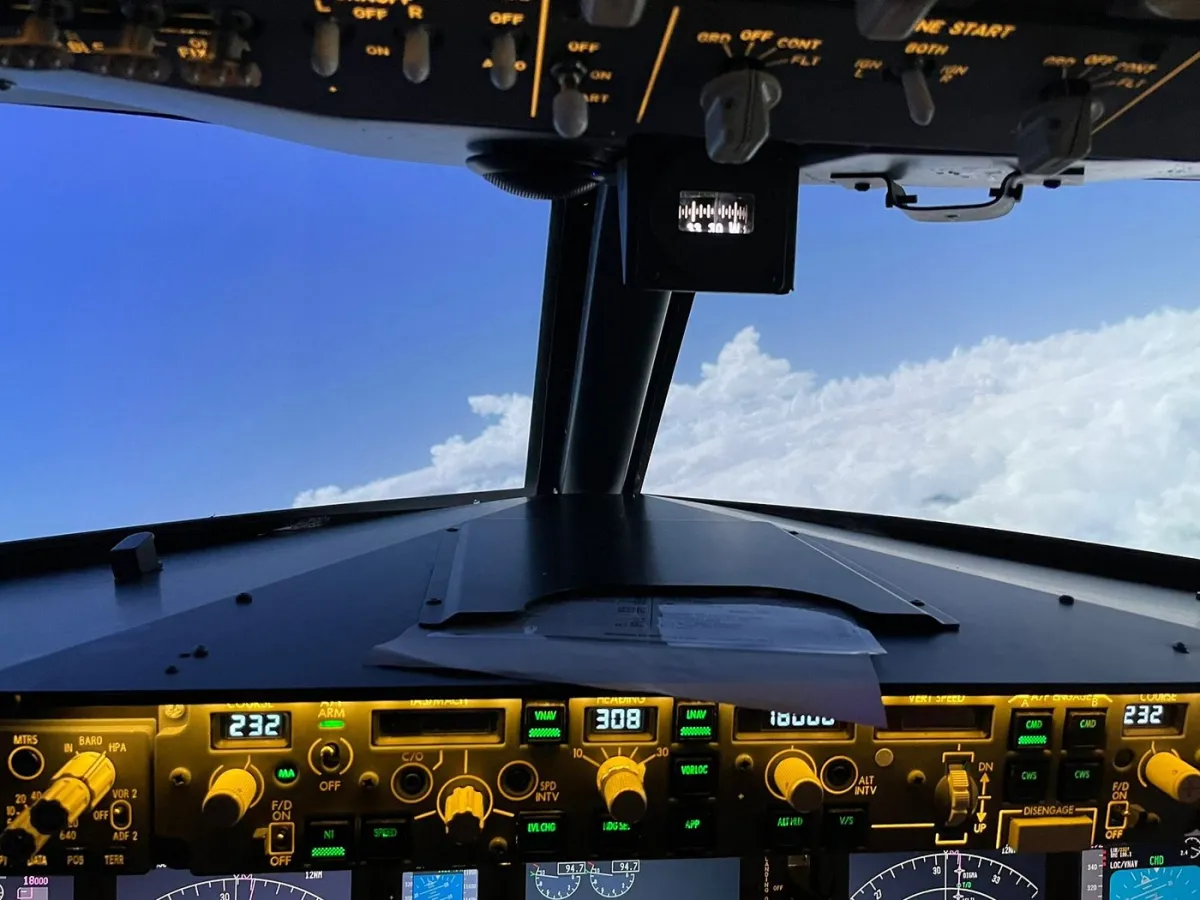 View from airplane cockpit showing clouds and sky.